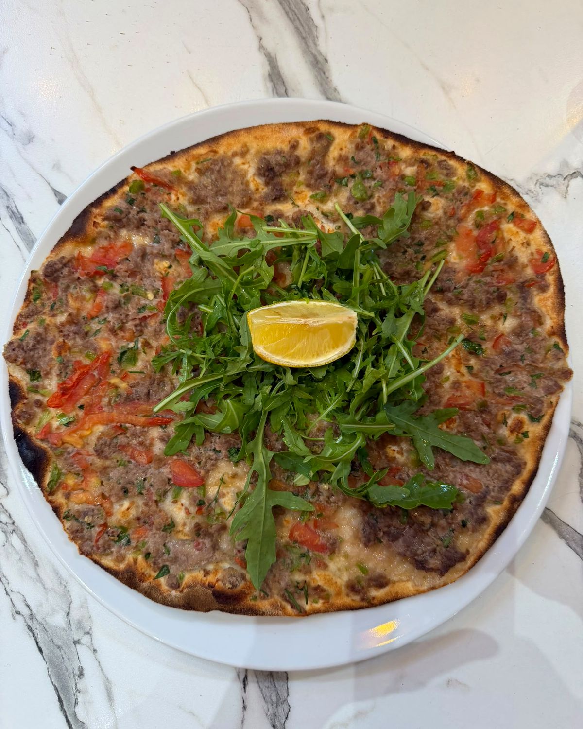 Antep lahmacun garni de roquette et d’un quartier de citron